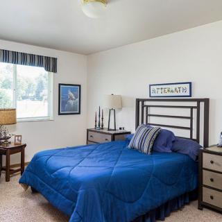 A cozy bedroom with a blue bedspread and matching decor.
