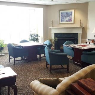 A cozy office meeting room with comfortable chairs and a fireplace.