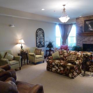 A cozy living room with various seating options, a fireplace, and elegant decor.