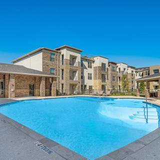 Modern apartment complex with a large outdoor swimming pool.