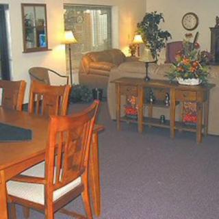 A cozy living and dining area with wooden furniture and ambient lighting.