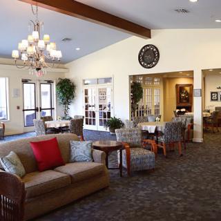 A cozy lobby area with comfortable seating, a chandelier, and a welcoming atmosphere.