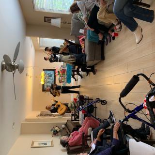A group of people gathered in a living room, enjoying music played on a guitar.