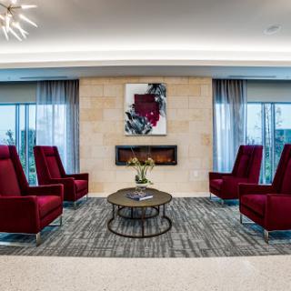 A stylish modern lounge area with red chairs and contemporary artwork.