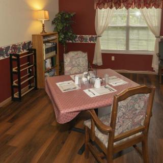 A cozy dining room setup with a table and chairs, complemented by warm lighting and elegant decor.