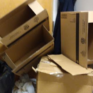 A collection of empty cardboard boxes stacked and scattered in a storage area.