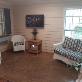 A cozy living room setup with armchair and sofa near a window.