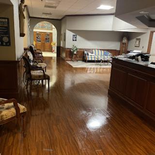A spacious waiting area featuring wooden flooring and comfortable seating.