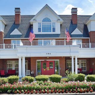 A traditional residential building with American flags and well-maintained landscaping.