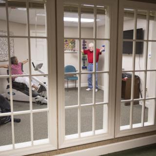 Participants engaged in a physical therapy session in a rehabilitation room, focusing on fitness and recovery.