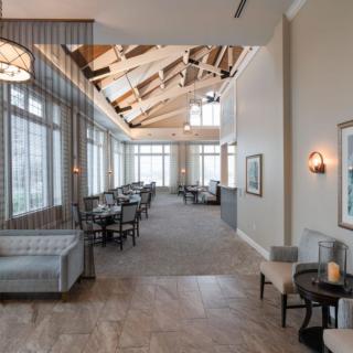 A spacious lounge area with ample seating and large windows allowing natural light to flood the room.