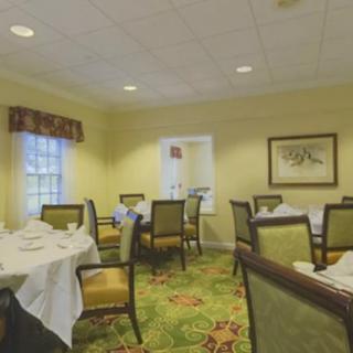 An empty dining room with neatly arranged tables and chairs in a cozy restaurant setting.