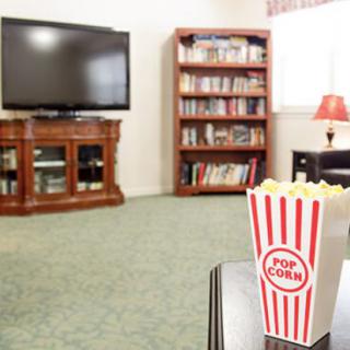 Cozy living room setup with a TV, bookshelf, and a box of popcorn.