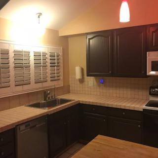 A modern kitchen with dark cabinets and a well-lit countertop area.