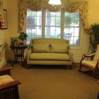 A cozy living room with a sofa, rocking chair, and decorative elements.
