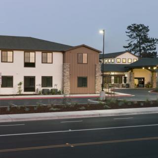 A view of a building complex next to a road in the evening.