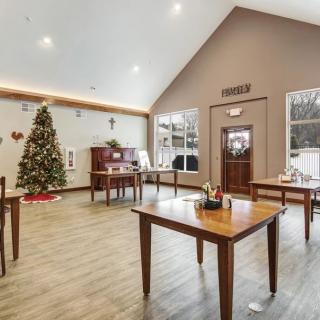 A warmly decorated room with wooden tables and a Christmas tree.