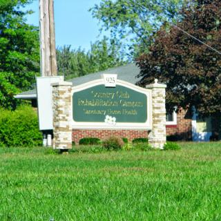 Entrance sign for a residential community surrounded by lush greenery.