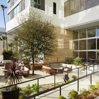 A modern outdoor patio area with seating and plants in an urban setting.
