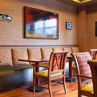 A cozy restaurant interior featuring comfortable seating with tables and decorative wall art.
