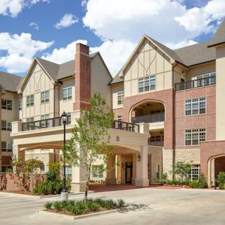 A modern residential apartment building with a brick and stucco facade.