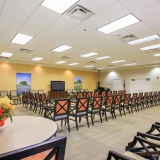 A spacious conference room arranged with rows of chairs and a projector for presentations.
