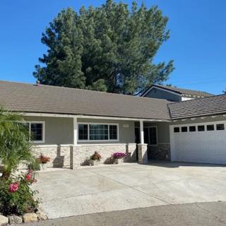 A suburban house with a driveway and garage on a sunny day.