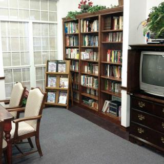 A cozy library corner with bookshelves, a TV, and seating area.