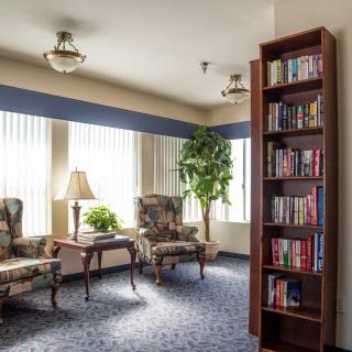 A cozy reading nook with a bookshelf, comfortable chairs, and abundant natural light.