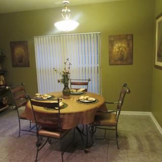 A cozy dining room with a round table set for four, surrounded by elegant decor and warm lighting.