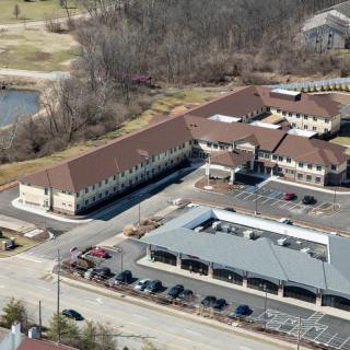 Aerial view of a complex with multiple buildings and a parking lot.