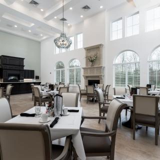 A modern dining area with elegant furnishings and large windows.