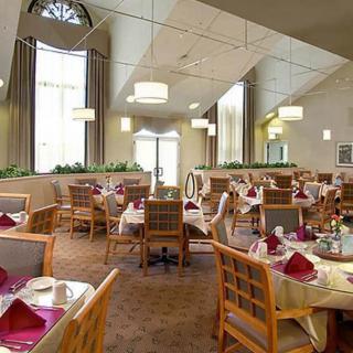 An elegant dining room set with tables and chairs, ready for guests.