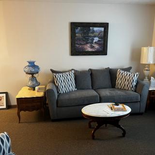 A cozy living room with a gray sofa, patterned cushions, and a coffee table.