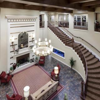 A grand lobby with a sweeping staircase and elegant chandelier.