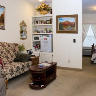 A cozy living room with floral sofa, coffee table, and wall decor.
