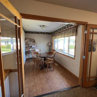 A cozy dining space featuring wooden furniture and ample natural light.