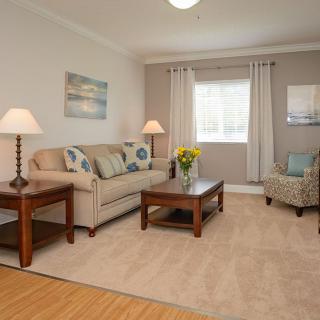 A cozy living room with a beige sofa, wooden coffee table, and neutral decor.