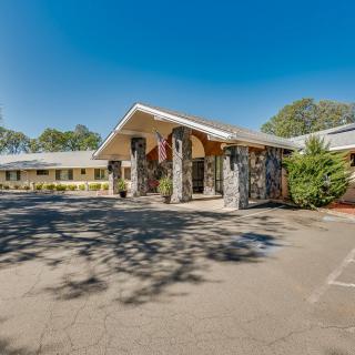 A motel entrance with a parking lot on a clear, sunny day.