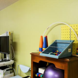 A therapy room showcasing various equipment and colorful toys.