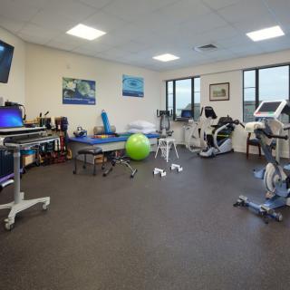 A well-equipped physical therapy room featuring various exercise machines and rehabilitation tools.