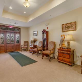 A cozy lobby area with wooden doors, elegant furniture, and warm lighting.