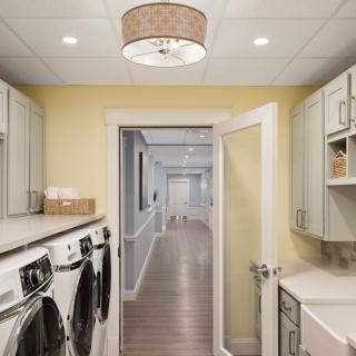 A tidy laundry room with modern appliances leading to a hallway.