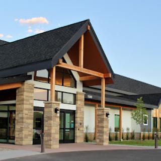 A modern building featuring a blend of stone and wooden architectural elements.
