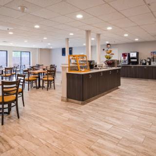 A spacious and modern dining area featuring comfortable wooden chairs and a coffee station.