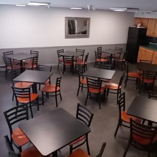 An empty dining area with several tables and chairs arranged for use.