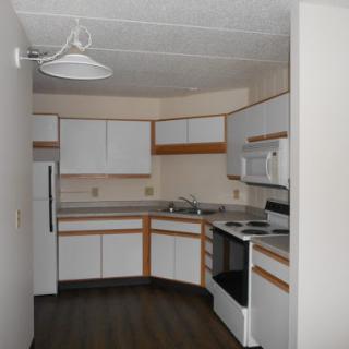 A modern kitchen featuring white cabinets and essential appliances.