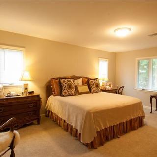 A cozy bedroom with a large bed, bedside tables, and warm lighting.