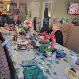 A joyful family gathering around a beautifully set table, celebrating with delicious food and fresh flowers.