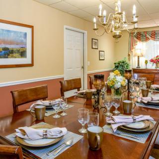 A beautifully set dining table in an elegant room with a chandelier.